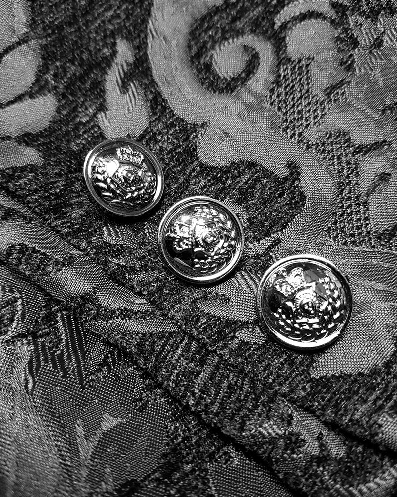 Crest buttons and brocade close-up